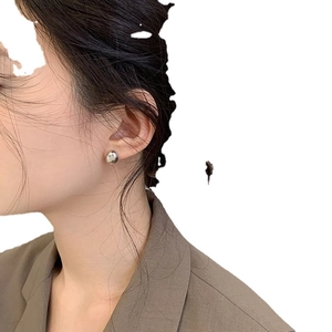Minimalist silver bean stud earrings with a high-polished metallic finish on female model