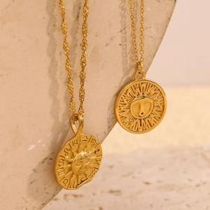 Détail macro de colliers célestes dorés avec masque solaire du zodiaque et pendentifs