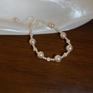 Détail d'un bracelet de perles avec billes argentées et chaîne de fermeture réglable