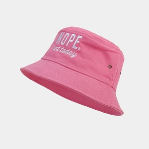 Detailed view of white slogan embroidery and metal eyelets on pink cotton bucket hat