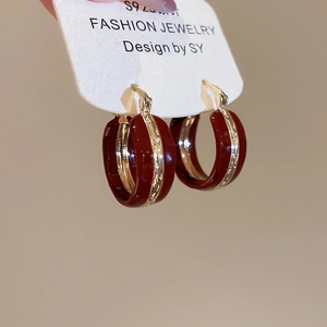 Close-up of burgundy enamel round hoop earrings with golden edges on S925 silver needles