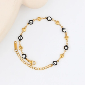 Detailed view of golden stainless steel evil eye bead bracelet with heart charms and lobster clasp