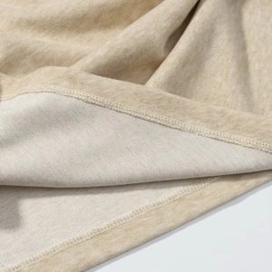 Macro shot of double stitching and soft knit fabric texture on oat beige set