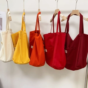 Detailed row of striped canvas tote bags in cream, yellow, orange, red, and burgundy colors