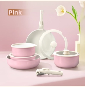 Detail of pink non-stick cookware set with detachable handles and glass lids