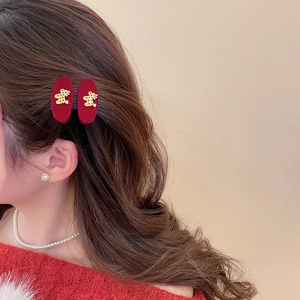 Detail of plush triangle hair clips with gold bear accents worn on dark brown wavy hair