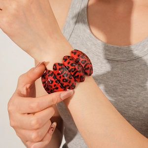Vue détaillée d'un large bracelet élastique en résine avec motif léopard rouge