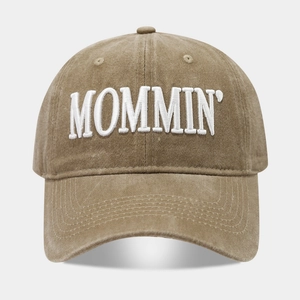 Close-up of white MOMMIN letter embroidery on khaki washed cotton baseball cap