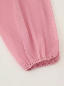 Detaillierte Makroansicht der rosa Chiffon-Kleid-Ärmel mit elastischem Rüschendesign