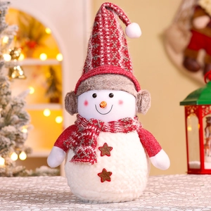 Close-up of a plush Christmas snowman doll with knit hat and scarf in warm festive setting