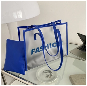 Detail of blue frosted transparent jelly tote bag set on desk with fashion accessories