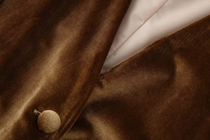 Detailed close-up of brown velvet blazer featuring fabric covered buttons and satin lining