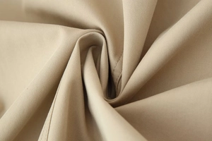 Macro detail of premium khaki twill trench coat fabric showing texture and drape