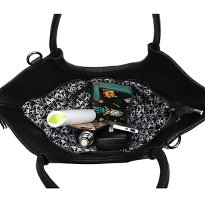 Detalle interior del gran bolso tote de cuero negro con un forro de calavera único.