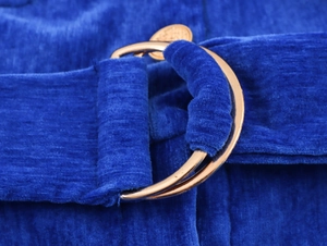 Dettaglio vestito blu in ciniglia con cintura a fibbia dorata e trama in velluto