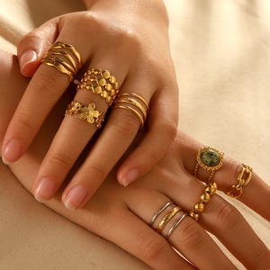 Set of multi-layered stainless steel rings in gold and turquoise on female hand