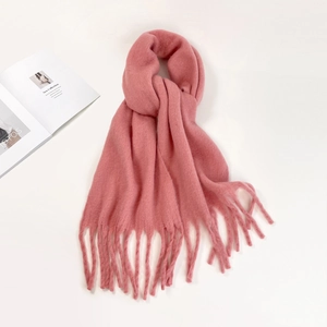 Close-up of pink mohair scarf with soft knitted texture and elegant fringe detail