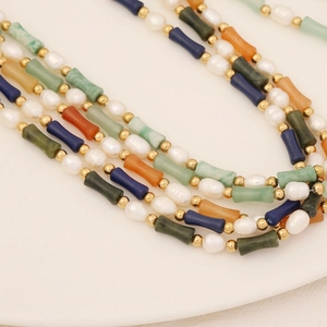 Detail view of colorful tube gemstone beads and pearls on a bohemian necklace