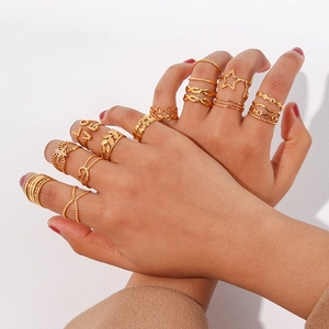 Detail of 18K gold stackable ring set featuring LOVE letters and braided woven textures