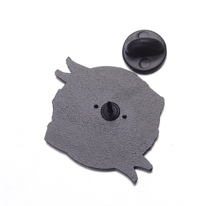 Detail of the pin badge back with matte black metal texture and rubber clutch attachment