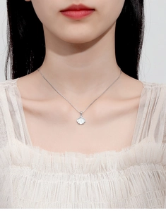 Detailed close-up of a 925 sterling silver shell pendant necklace on a female model
