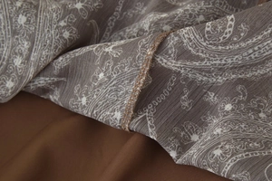 Détail du tissu paisley taupe avec mise au point sur la couture de surjet de qualité