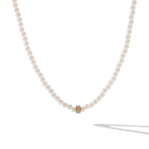 Elegant pearl necklace with gold diamond ring charm on a minimalist white background