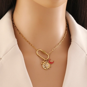 Gold U-shape clasp necklace with star, sun-moon, and red crescent pendants on a model