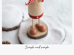Detail of wooden Christmas figurine legs with striped fabric on a red polka dot base