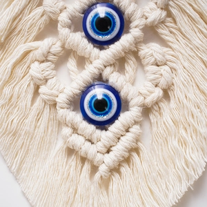 Detailed macro shot of bohemian cotton rope macrame and blue evil eye glass beads