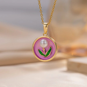 Macro detail of tulip enamel pendant with white pearl and gold leaf chain