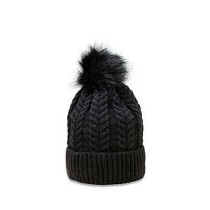 Close-up of black cable knit beanie with faux fur pom pom and ribbed folded brim