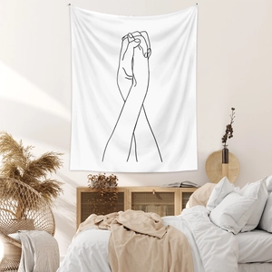 Detail of minimalist line art tapestry with hand-holding design in a modern bedroom