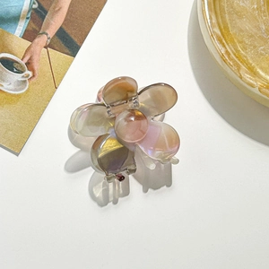 Nahaufnahme der floralen Haarklammer mit perlmuttfarbenem Pink-Gold-Verlaufseffekt