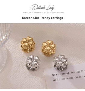 Detail shot of three-dimensional gold and silver clover earrings on elegant fabric