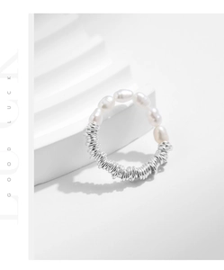 Detail of baroque pearls and silver wire-wrapped elastic ring on white stairs