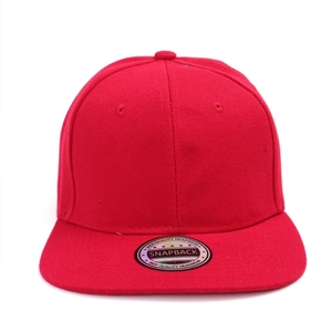 Detailed close-up of a red snapback baseball cap with ventilation eyelets and logo sticker