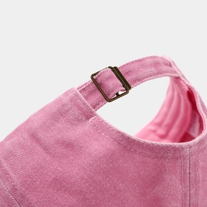Detail der verstellbaren Messingschnalle und des rosa gewaschenen Baumwollstoffs
