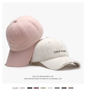 Close-up of embroidered baseball caps with distressed brim detail in pink and beige
