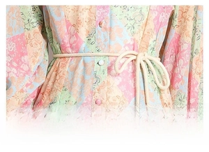 Detail of floral long sleeve dress showing woven rope waist belt and button closure