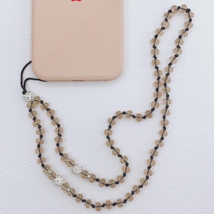 Detail of brown crystal beads and silver rhinestone ball on a DIY mobile phone lanyard