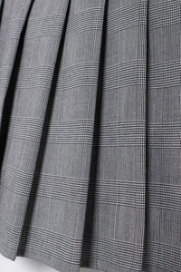 Vue macro détaillée de la texture du tissu écossais gris et des plis sur cette jupe-culotte femme