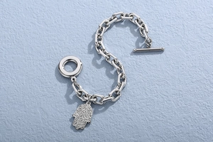 Detail view of silver Hamsa Hand bracelet with OT toggle clasp on blue background
