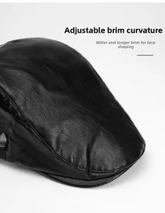 Detail of a black leather newsboy cap showing the foldable, widened and lengthened brim