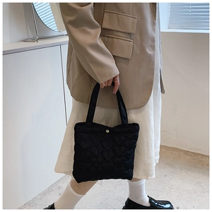 Detail of black oxford tote bag with minimalist heart-shaped quilted stitching