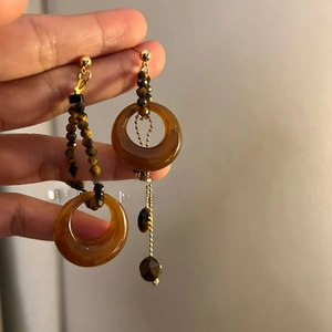Detailed view of vintage resin tiger eye earrings with golden metal accents and beads