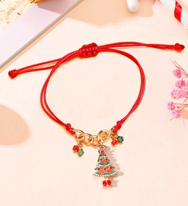 Detail of red braided Christmas bracelet with a green tree pendant and golden chain link