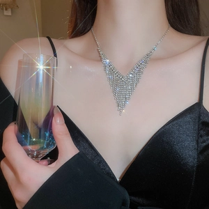 Gros plan d'un collier en V à franges en zircon argenté étincelant sur un mannequin
