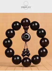 Macro detail of dark sandalwood prayer beads featuring twin gourd pendants and 12 beads