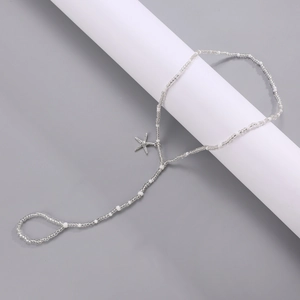 Detail of beach beaded anklet with silver starfish pendant and toe ring design